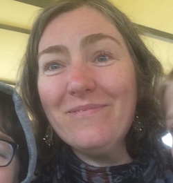 A close up photograph of Emma Rawlins, smiling at the camera with two children, a boy and girl, alongside her