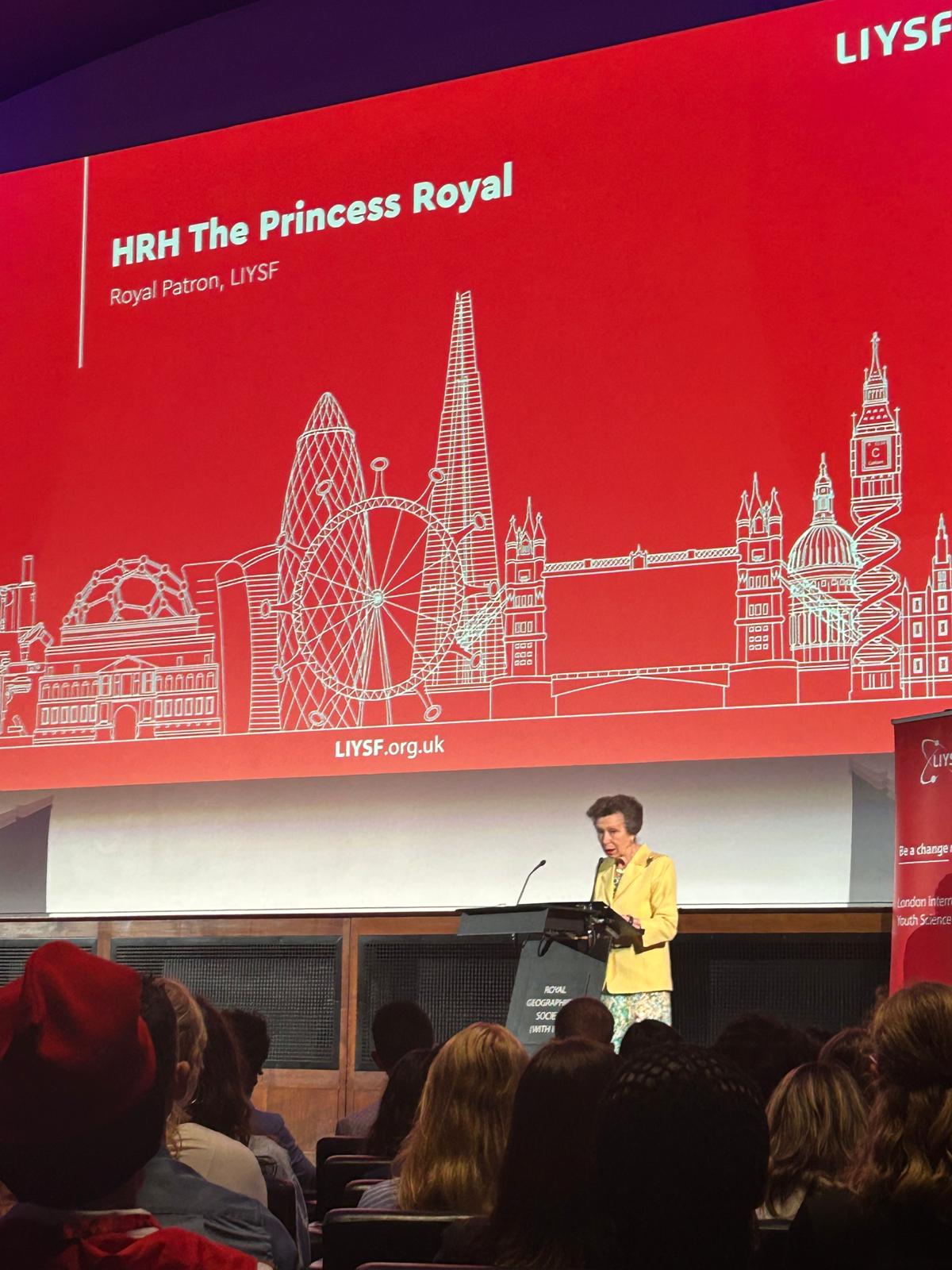 HRH The Princess Royal stands at a podium giving a speech to the audience at the LIYSF