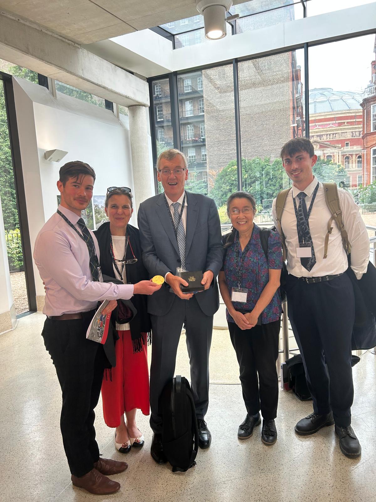 Members of the Human Anatomy Centre team stand with Professor Sir David Macmillan. He is holding his Nobel Prize medal