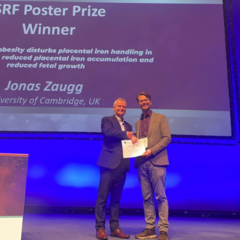 Jonas Zaugg accepts the Society of Reproduction and Fertility Poster Prize, onstage at the Fertility 2024 conference in Edinburgh