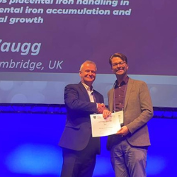 Jonas Zaugg accepts the Society of Reproduction and Fertility Poster Prize, onstage at the Fertility 2024 conference in Edinburgh