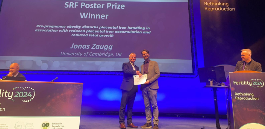 Jonas Zaugg accepts the Society of Reproduction and Fertility Poster Prize, onstage at the Fertility 2024 conference in Edinburgh